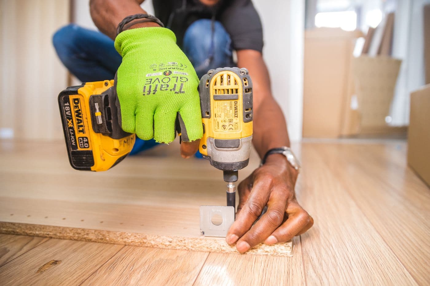 Hands using a power drill during indoor carpentry work